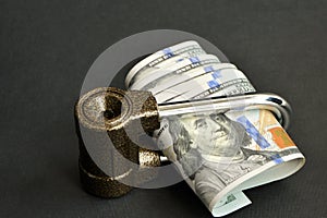 US dollar bills wrapped in the lock on a black background.