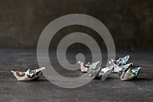 US Dollar paper boat on dark background. Many Ships from a money