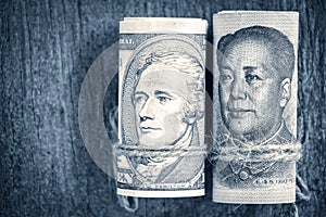 US dollar versus china yuan banknote on the wooden table background. The concept of business growth, financial or trade war