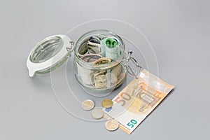 Us dollars and Euro banknotes in a glass jar. Bills and coins in a piggy bank. Save money. World Financial crisis.