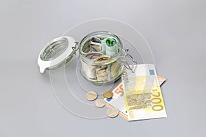 Us dollars and Euro banknotes in a glass jar. Bills and coins in a piggy bank. Save money. World Financial crisis.