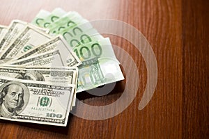 US dollars and euro banknotes texture. dark wood Background of one hundred dollar and euro bills