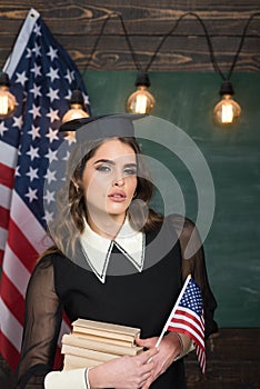 US flag and blackboard. Teacher helping kids with computers in elementary school on the USA national flag background