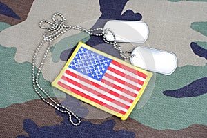 US flag patch with dog tags on woodland camouflage uniform