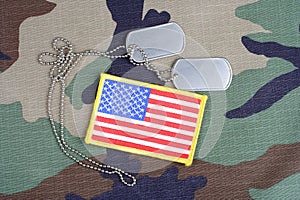 US flag patch with dog tags on woodland camouflage uniform