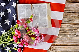 US flag with praying over a open reading Holy Bible on a close up of america pray