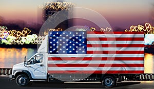 US flag on the side of a white van against the backdrop of a blurred city and river. Logistics concept
