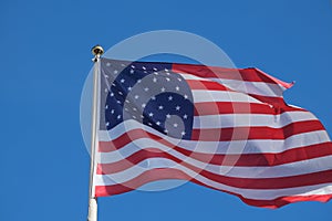 US flag soars into blue sky