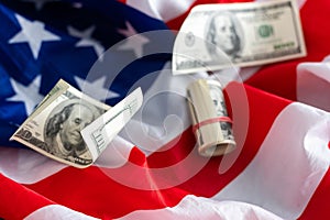 US flag. Stock market prices chart under the flag. Rolled one hundred us dollar bill lying on the flag. Two lines on the