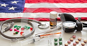 US health. Medical instruments and pills on a USA flag, closeup view