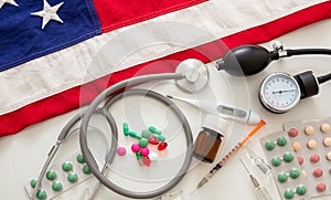 US health. Medical instruments and pills on a USA flag, top view