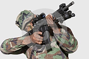 US Marine Corps soldier aiming M4 assault rifle against gray background photo