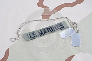 US MARINES branch tape with dog tags on desert camouflage uniform