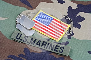 US MARINES branch tape, flag patch and dog tags on woodland camouflage uniform