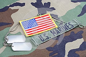 US MARINES branch tape, flag patch and dog tags on woodland camouflage uniform