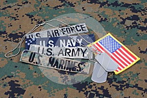 US MILITARY concept with branch tapes and dog tags on camouflage uniform