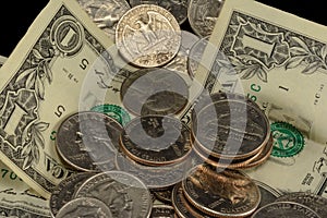 US Money, dollars, dimes, nickels and quarters piled randomly photo