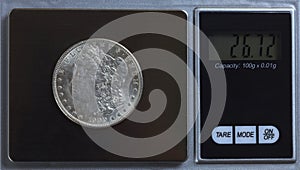 US Morgan silver dollar being weighed on digital scale