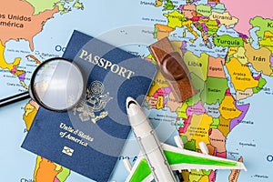US passport, stamp, airplane and magnifying glass on a map of the world. Business trip. Holiday and adventure. Travel search