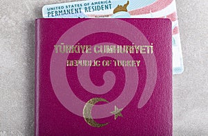 A US permanent resident card a.k.a Green card inside a Turkish passport.