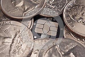 US quarters lie around a bank plastic card chip close-up. American coins, money, online trading, payments and transfers