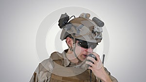 US ranger in uniform talking on radio on gradient background.