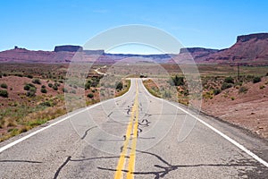 US road 128 winding through Utah desert between red cliffs on abeautiful day of spring. Scenic drive through American