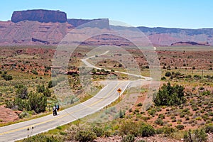 US road 128 winding through Utah desert between red cliffs on abeautiful day of spring. Scenic drive through American