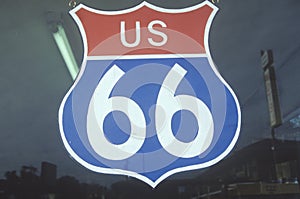 A US route 66 sign hanging in a window