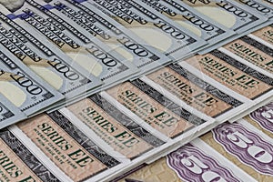 US Savings Bonds and 100 Dollar bills, representing investment choices. Savings bonds are debt securities issued by the U.S.