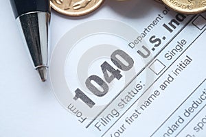 US tax form with pen and coins on table, close up