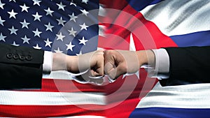 US vs Cuba conflict, international relations crisis, fists on flag background