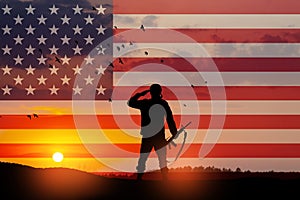 USA army soldier saluting on a background of USA flag. Greeting card for Veterans Day, Memorial Day, Independence Day.