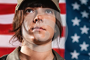 USA celebration. Close-up portrait of a female soldier, against the background of the American flag