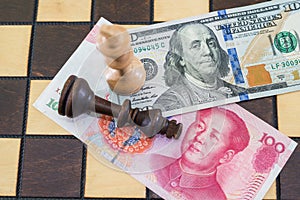 USA and China financial trade war concept, black and white chess king on US dollar and RMB banknotes