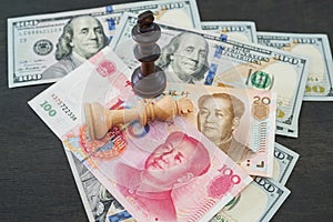 USA and China financial trade war concept, black and white chess king on US dollar and RMB banknotes