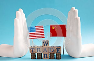 USA and China flags, coins and phrase Trade war made of wooden cubes on light blue background