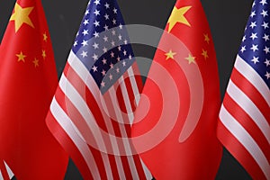 USA and China flags on dark background, closeup. International relations