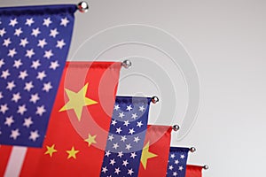 USA and China flags on light background, closeup. International relations