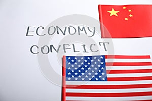 USA and China flags near words ECONOMY CONFLICT on white background