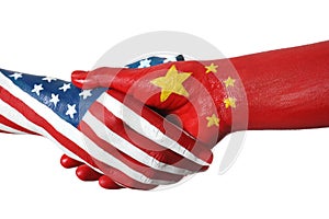 USA and China partnership. People shaking hands painted in flags on background, closeup