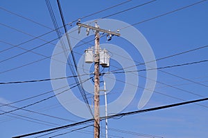 Electrical installation in the USA. Oil transformers on a wooden pole. If mounted on a utility pole, they are called pole-mount