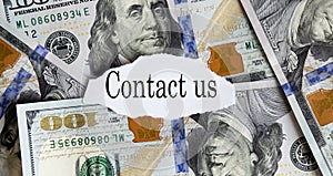 USA dollar with finance text CONTACT US on the torn piece paper