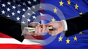 USA and EU officials exchanging money, flag background, international trade