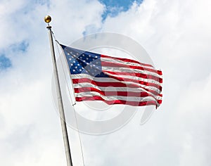 USA flag on blue sky with clouds