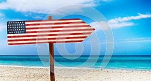 USA flag on wooden table sign on beach background. It is summer sign of USA