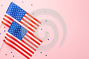 USA Independence Day concept. Top view photo of two national flags and confetti on isolated pastel pink background with copyspace