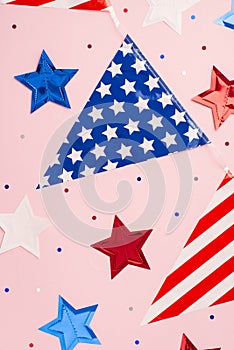 USA Independence Day concept. Top view vertical photo of national flag garland stars and confetti on isolated pastel pink