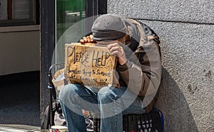 New York, Manhattan downtown. Homeless man holding a cardboard sign, begging