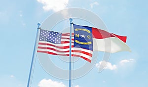 USA and state North Carolina, two flags waving against blue sky